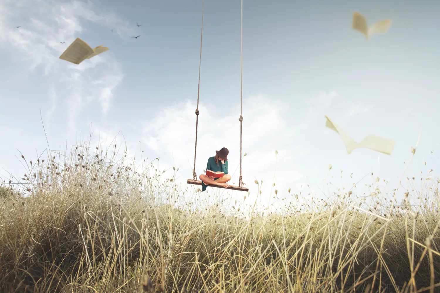 Eine Frau auf einer frei schwebenden Schaukel liest ein Buch, umgeben von fliegenden Seiten, die wie Vögel aussehen.
