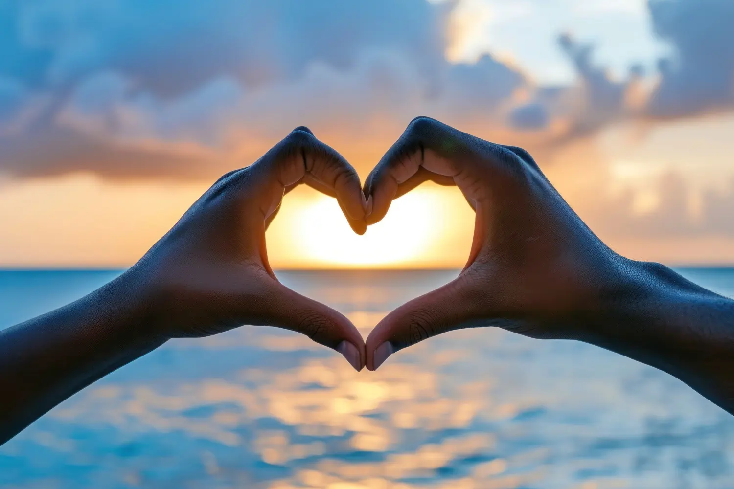 Zwei Hände formen ein Herz, Ruhe am Meer.